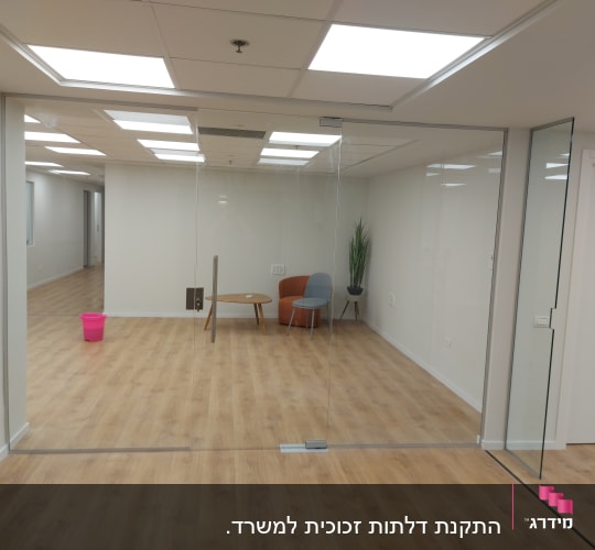 דלת זכוכית שקופה במשרד עם רצפת עץ